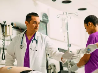 A healthcare professional supporting a patient during treatment